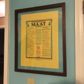 Brown wooden picture frame with yellow poster listing the 42 negative confessions of MA'AT.